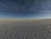 the sky is clear as it sits on the snowy field in the middle of the desert