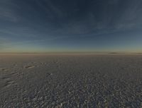 the sky is clear as it sits on the snowy field in the middle of the desert