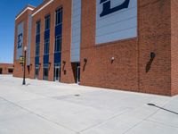 a building with the side door opened, showing the front of a parking lot and sign on a post