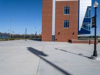 a street light near a building and a walkway next to it and the water behind it