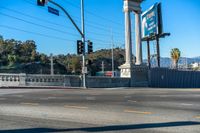 this city street is marked for an intersection where there is a tall column with a white top and columns along it