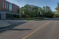 the empty road is lined with trees and buildings on either side of it in the summer