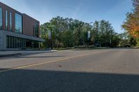 the empty road is lined with trees and buildings on either side of it in the summer