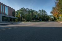 the empty road is lined with trees and buildings on either side of it in the summer