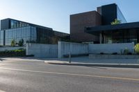 two bicycles parked on the side of a road next to a building with a tall glass facade