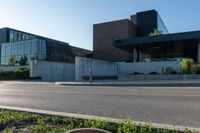 two bicycles parked on the side of a road next to a building with a tall glass facade