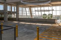 empty parking lot with an airplane hanging from the ceiling and yellow posts in front of it