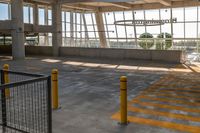 empty parking lot with an airplane hanging from the ceiling and yellow posts in front of it