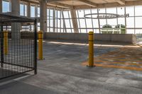 empty parking lot with an airplane hanging from the ceiling and yellow posts in front of it