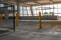 empty parking lot with an airplane hanging from the ceiling and yellow posts in front of it