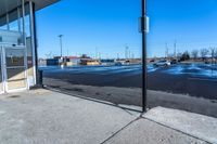 empty parking lot with a closed business and signs on the sidewalk in front of it