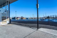 empty parking lot with a closed business and signs on the sidewalk in front of it