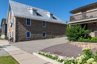 the home is near a well maintained brick street with flowers and flowerspots in front