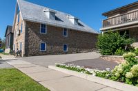 the home is near a well maintained brick street with flowers and flowerspots in front