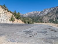 the dirt road has been cleared out by mountains and trees in it's direction