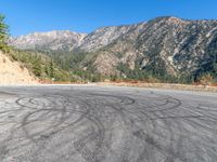 a tire is painted on the road near the mountains in this photo is taken from a car