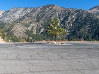 an empty parking lot in front of some mountains with the sky in the background,