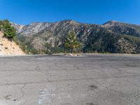 an empty parking lot in front of some mountains with the sky in the background,