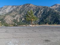 an empty parking lot in front of some mountains with the sky in the background,