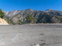 an empty parking lot in front of some mountains with the sky in the background,