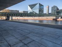 a skateboard sits outside a concrete structure that is next to a street area with a bench