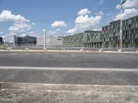 an empty street is seen behind the fenced off area in front of a large building