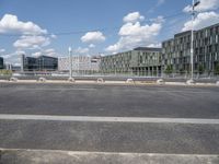 an empty street is seen behind the fenced off area in front of a large building