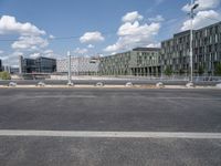 an empty street is seen behind the fenced off area in front of a large building