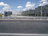 an empty street is seen behind the fenced off area in front of a large building