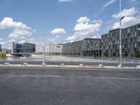 an empty street is seen behind the fenced off area in front of a large building