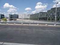 an empty street is seen behind the fenced off area in front of a large building