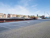 a large boat sits docked in a marina at the end of a street next to brick pavement