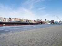 a large boat sits docked in a marina at the end of a street next to brick pavement