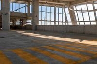 a yellow crosswalk in a building with large windows and light coming through it that says