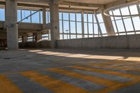 a yellow crosswalk in a building with large windows and light coming through it that says