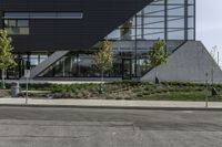 a building has several plants on either side and a bus driving down the street in front