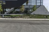 a building has several plants on either side and a bus driving down the street in front