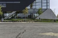 a building has several plants on either side and a bus driving down the street in front