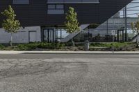 a building has several plants on either side and a bus driving down the street in front