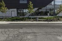 a building has several plants on either side and a bus driving down the street in front