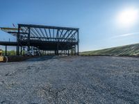 a picture of a building being built on a field near a forest in the background