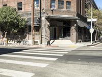 an intersection at two streets has traffic lights, and a bicycle and pedestrian sign on it