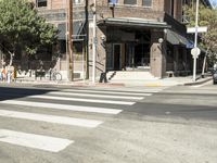 an intersection at two streets has traffic lights, and a bicycle and pedestrian sign on it