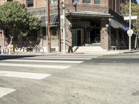 an intersection at two streets has traffic lights, and a bicycle and pedestrian sign on it