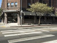 an intersection at two streets has traffic lights, and a bicycle and pedestrian sign on it