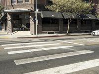 an intersection at two streets has traffic lights, and a bicycle and pedestrian sign on it