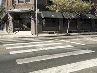 an intersection at two streets has traffic lights, and a bicycle and pedestrian sign on it