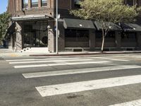 an intersection at two streets has traffic lights, and a bicycle and pedestrian sign on it