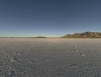 the sky is clear and clear on this desert area with small footprints on the ground