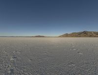 the sky is clear and clear on this desert area with small footprints on the ground